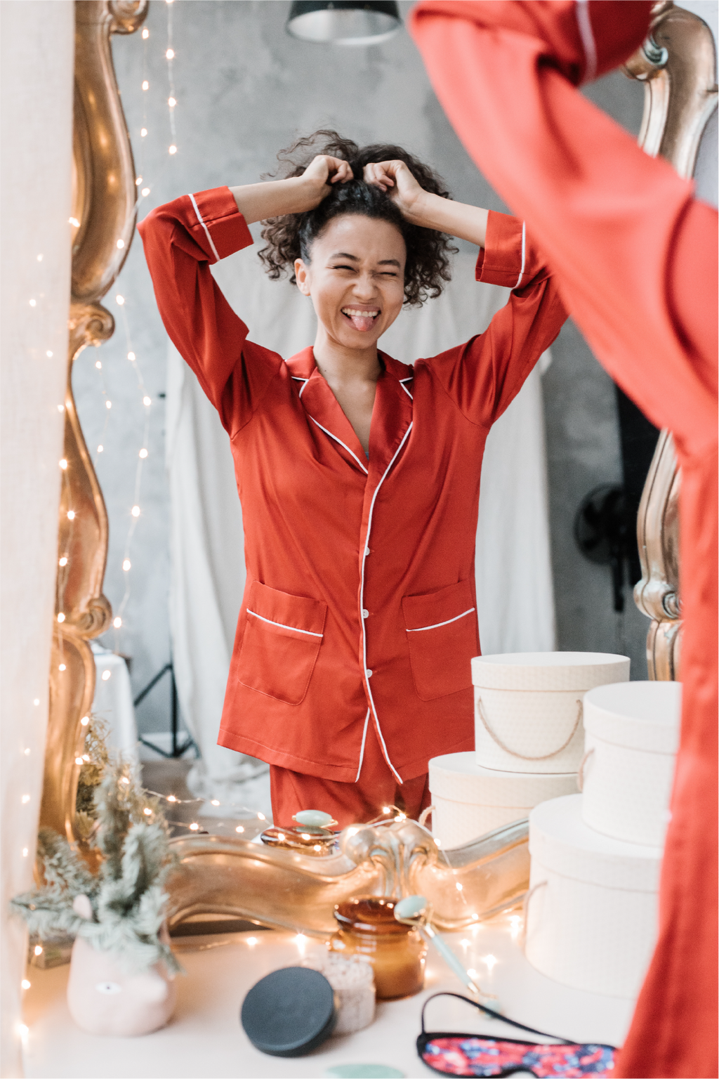 African American woman looking into mirror while in pajamas
