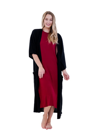 Blonde haired young woman modeling a black lounge comfort robe.